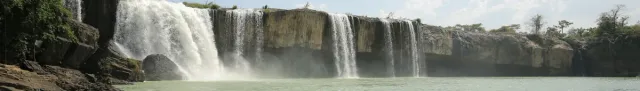 מפל רחב שנופל ממדף סלע לאורך כל רוחב הפריים